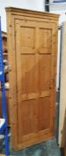 Pine floor-standing corner cupboard with panelled door opening to reveal shelves, on plinth base,
