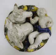 Continental pottery plaque, 20th century, in the Della Robbia-style, applied with a scantily