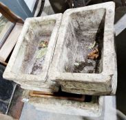 Set of four composite stone garden troughs or jardinieres with moulded scroll work decoration