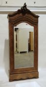 Continental walnut armoire with carved pediment, mirrored door, on bracket feet, 104cm x 240cm