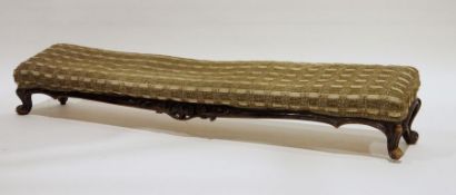 Narrow low footstool upholstered and on carved framed and squat cabriole legs, 134cm wide