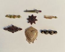 Gold-coloured metal and garnet star-shaped brooch, another shaped rectangular, antique gold pique