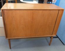 Mid century modern teak cabinet, the rectangular top above tambour door, on cylindrical tapering