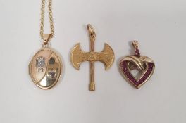 Gold-coloured metal double-headed battle axe pendant on fine gold chain, a gold red stone set