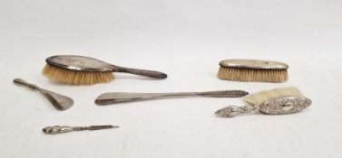 Silver-backed dressing table items to include brushes, a steel shoe horn, a silver-handled shoe horn