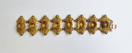 Gold-coloured metal ornate citrine set bracelet, each shaped panel set with oval citrine-coloured