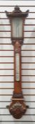 Mercury stick barometer and thermometer in ornately carved mahogany case