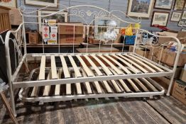 Cream painted tubular day bed with pull-out bed under