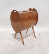 Mid-century teak sewing box with lift-top compartment above the oval sides, with fall compartment,
