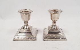 Pair of George V silver weighted squat candlesticks with square stepped base, Chester 1910, maker'