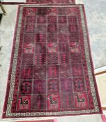 Large Turkish style red ground rug with repeating stylized animal and geometric design with