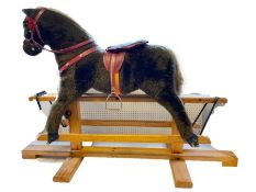 Modern rocking horse with brown fur, red saddle on pine platform base