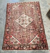 Large Eastern style pink ground rug with central lozenge medallion on a herati-filled field with