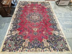 North East Persian Signed red ground Meshed carpet with large centralised floral medallion
