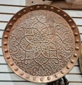 Large circular copper tray with embossed decorations and bosses around the interior rim 36cms diam