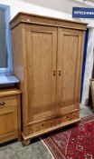 Early 20th century pine wardrobe with pair of cupboards, pair of drawers below, on bun feet, H.