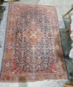 Eastern style red ground rug with central floral medallion on floral trelliswork field, herati