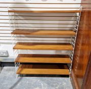 1960's/'70's String teak five shelf unit, supported by white metal laddered sides, (unstable,