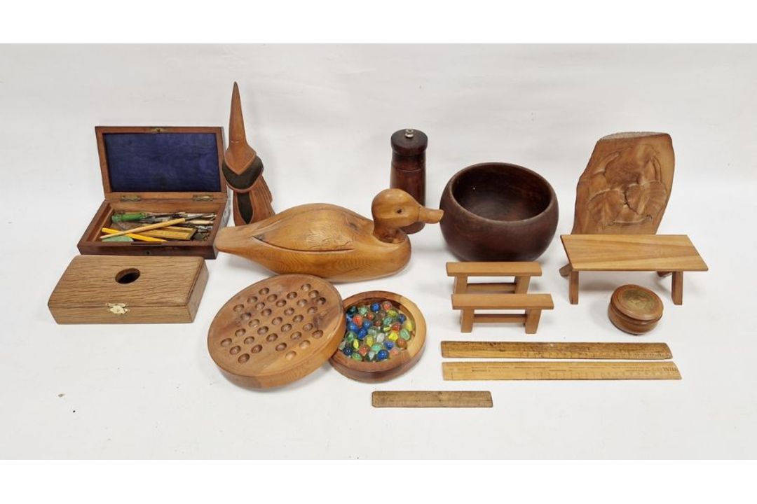 Wooden decoy duck, a turned wooden pepper mill, a wooden solitaire stand with marbles to base, a