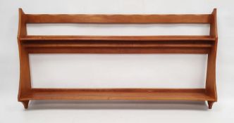 1970 Oliver Morel Cotswold School cherrywood wall rack, the top rail with scalloped edge, two