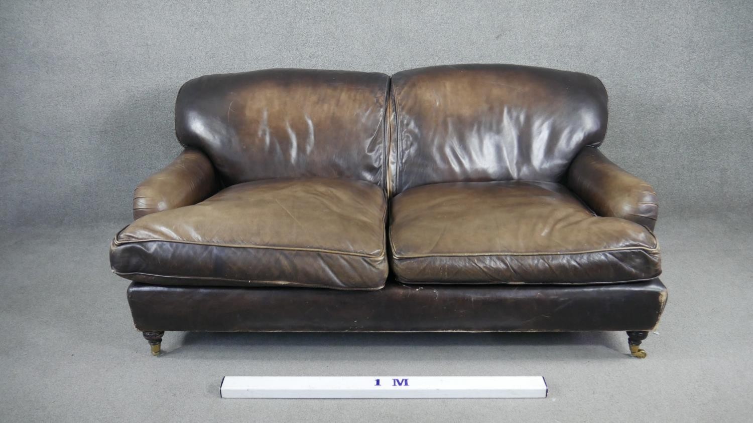 A Howard style two seater sofa in leather upholstery on turned supports terminating in brass - Image 7 of 7