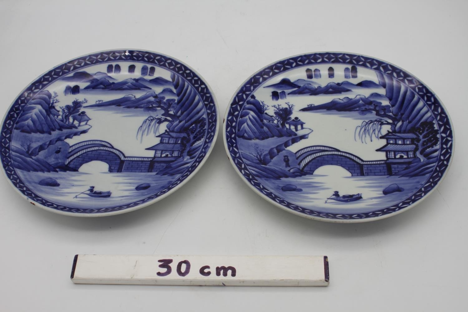 A pair of Japanese Arita style porcelain blue and white chargers hand painted with a landscape - Image 5 of 5