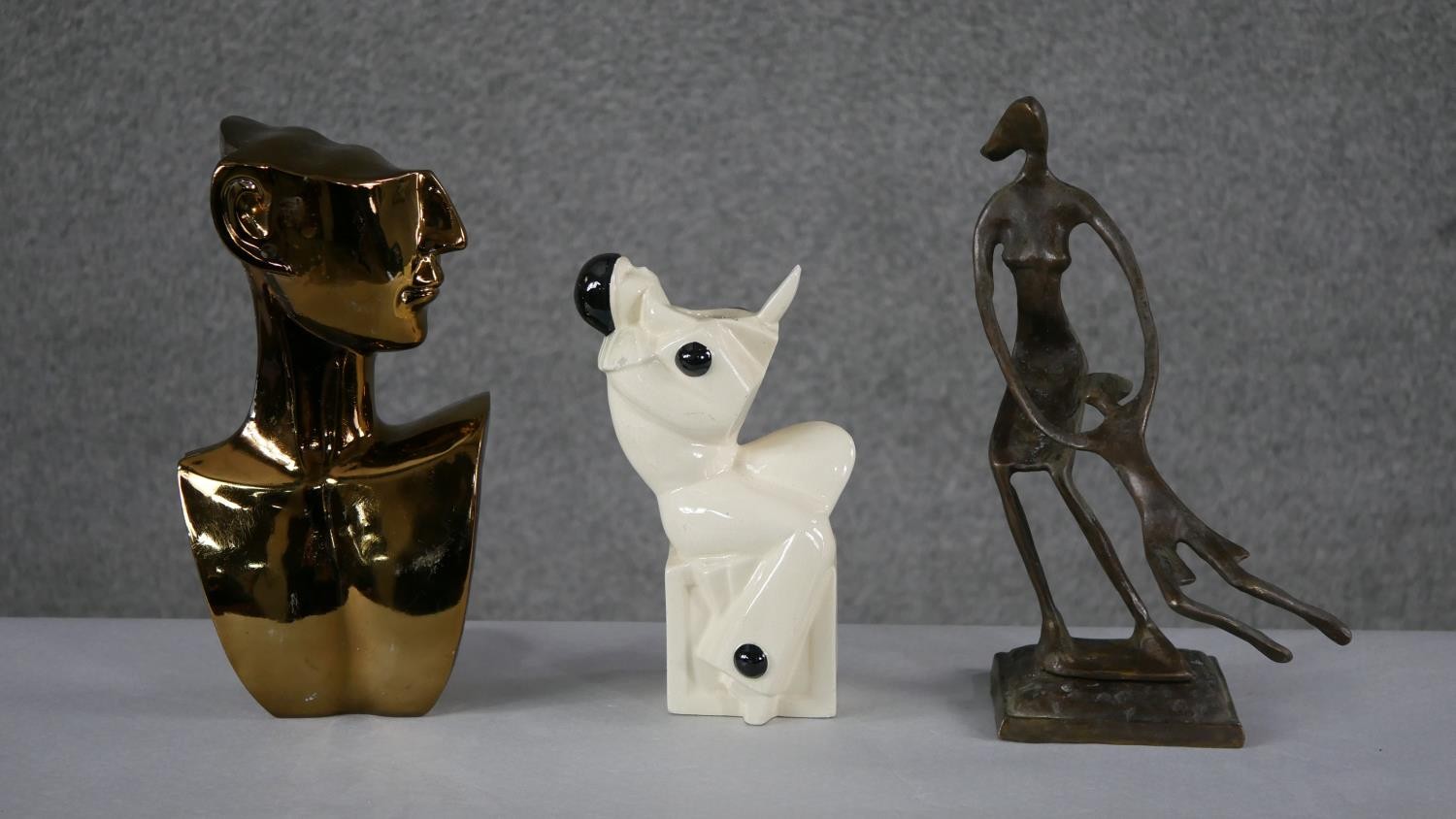 An Art Deco ceramic minstrel vase, a bronze effect moulded figure of a mother swinging her child and