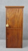 An early C20th pedestal cabinet with twin locking panel doors enclosing shelves. H.118 W.52 D.52cm