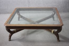 An Empire style coffee table with shaped bevelled plate glass top on cross stretchered base. H.44