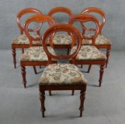 A matched set of six Victorian mahogany shaped and carved back dining chairs on turned tapering