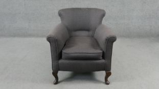 An early 20th century tub armchair in piped calico upholstery on mahogany cabriole supports.