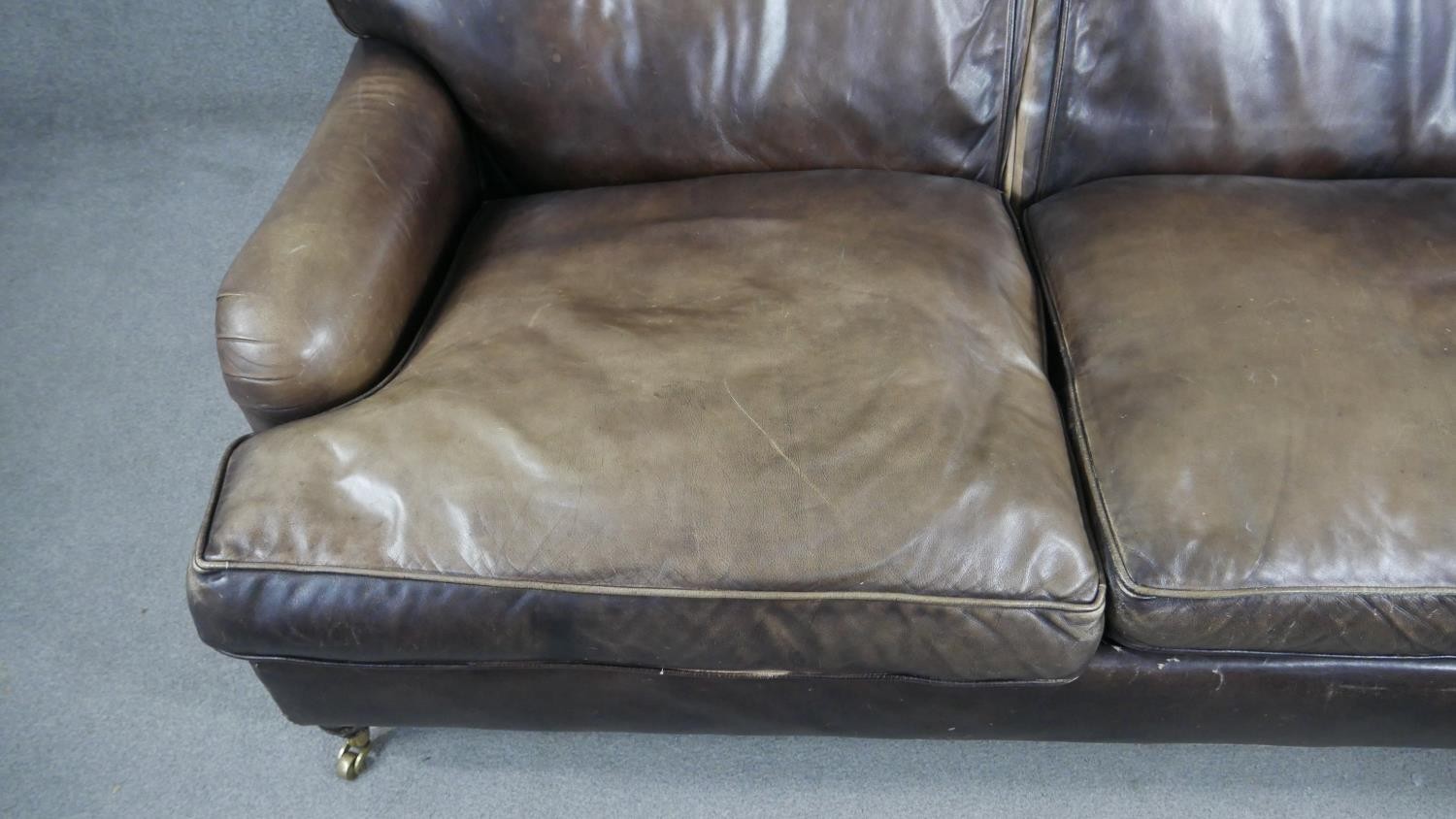 A Howard style two seater sofa in leather upholstery on turned supports terminating in brass - Image 3 of 7