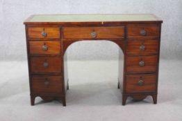 A 19th century mahogany pedestal desk with inset green tooled leather top above an arrangement of