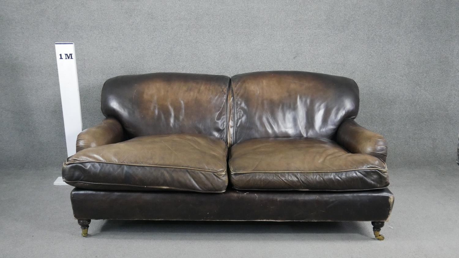 A Howard style two seater sofa in leather upholstery on turned supports terminating in brass - Image 6 of 7