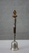 A Tibetan Buddhist temple bell, phurba and lotus flower gilded finial, encased hardwood shaft with
