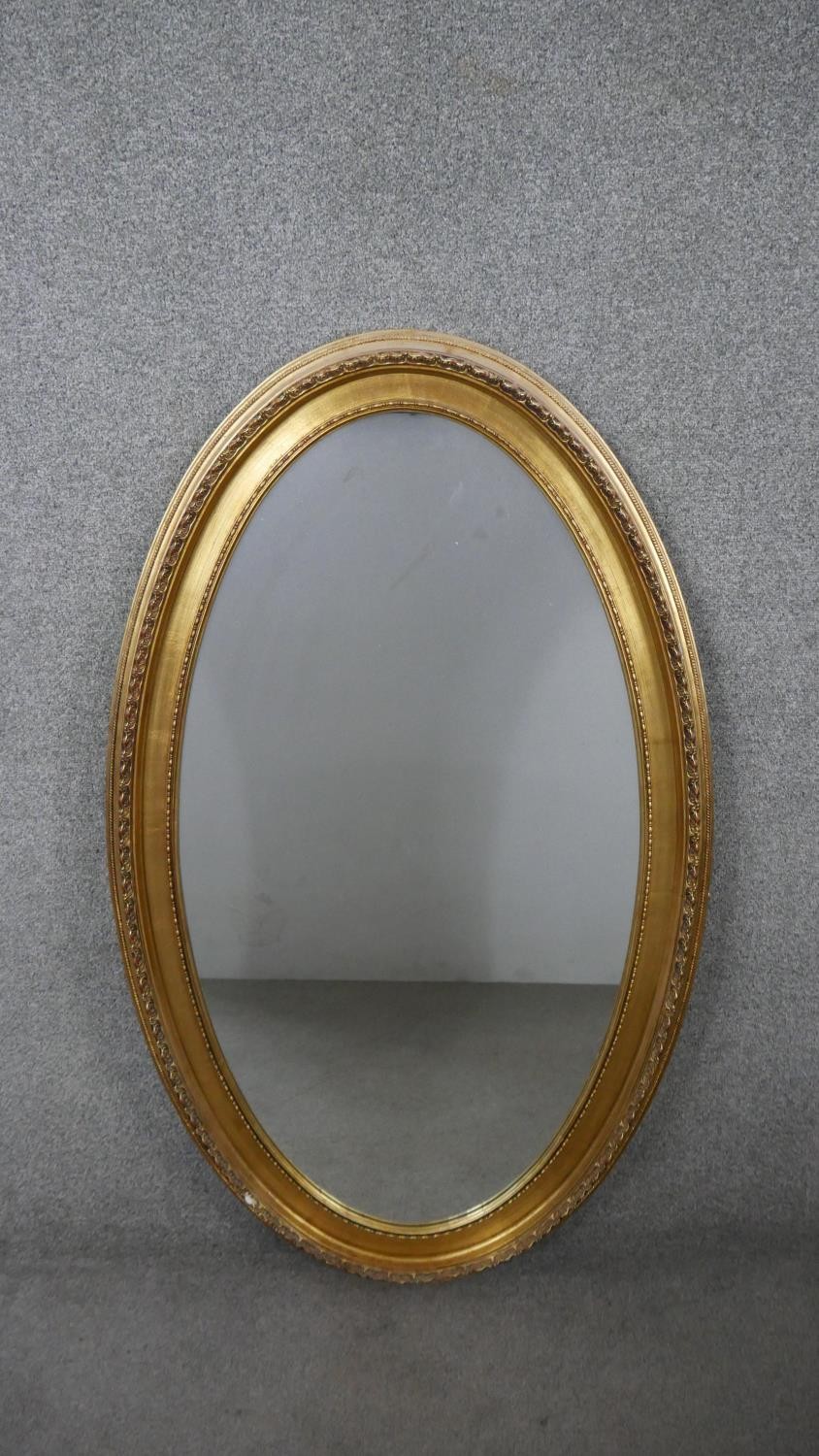 A large 20th century gilt framed wall mirror with beaded detailing. H.126 W.75cm