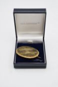 A yellow metal plated Victorian mourning brooch with plaited hair panel under glass to the front and