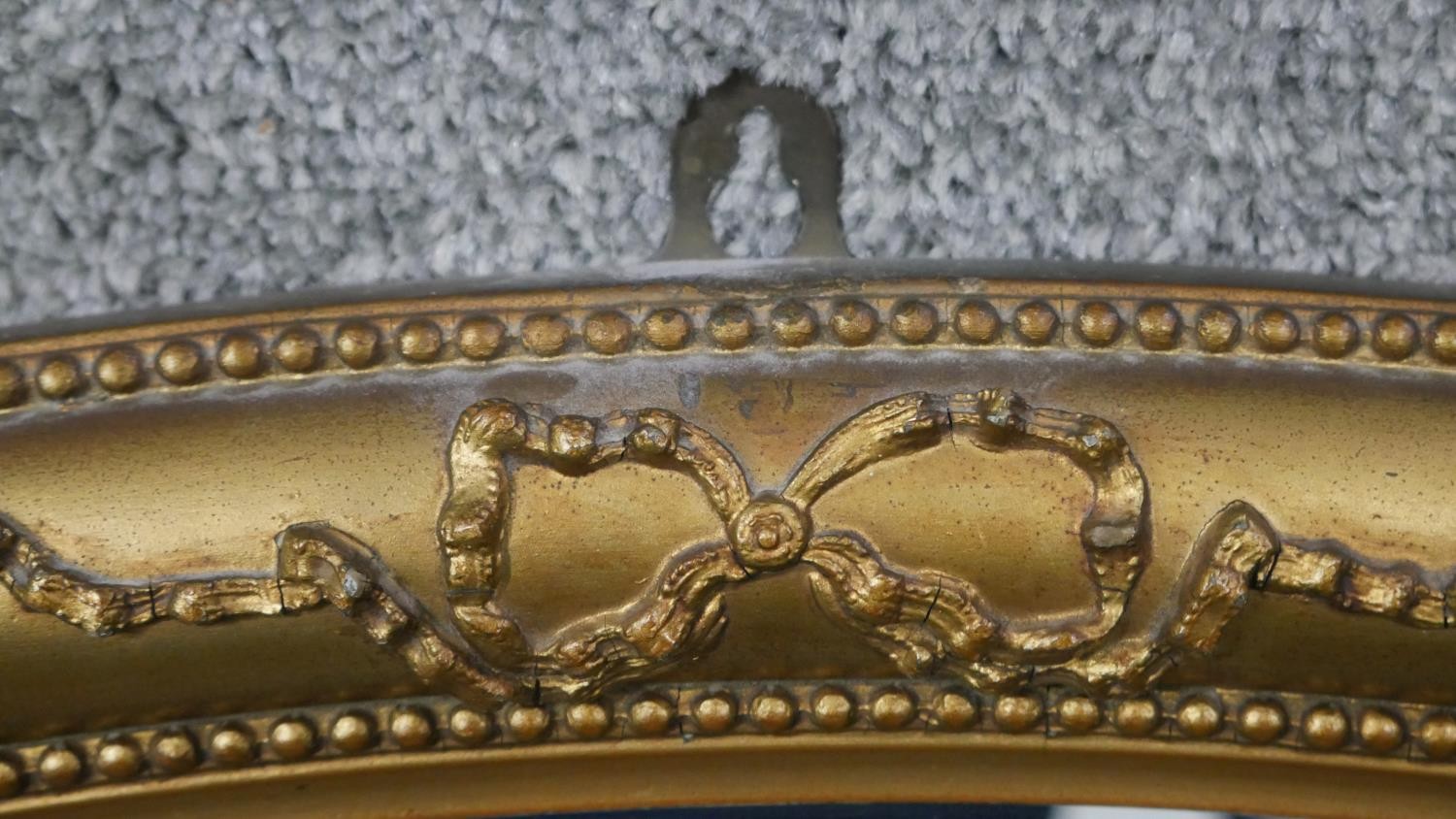 A C.1900 oval wall mirror in gilt ribbon and beaded gesso frame. H.50 W.78cm - Image 4 of 5