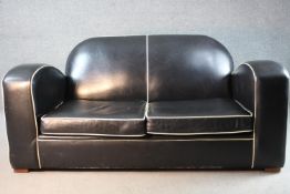 An Art Deco two seater sofa in piped leather upholstery on block supports. H.80 W.170 D.85 cm