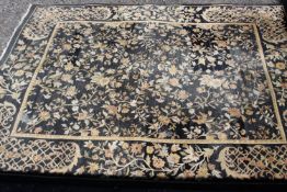 An Indian sari silk carpet with all over scrolling foliate decoration within a complementary border.