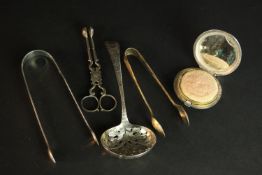 A collection of silver, including a engine decorated silver makeup compact, three pairs of sugar