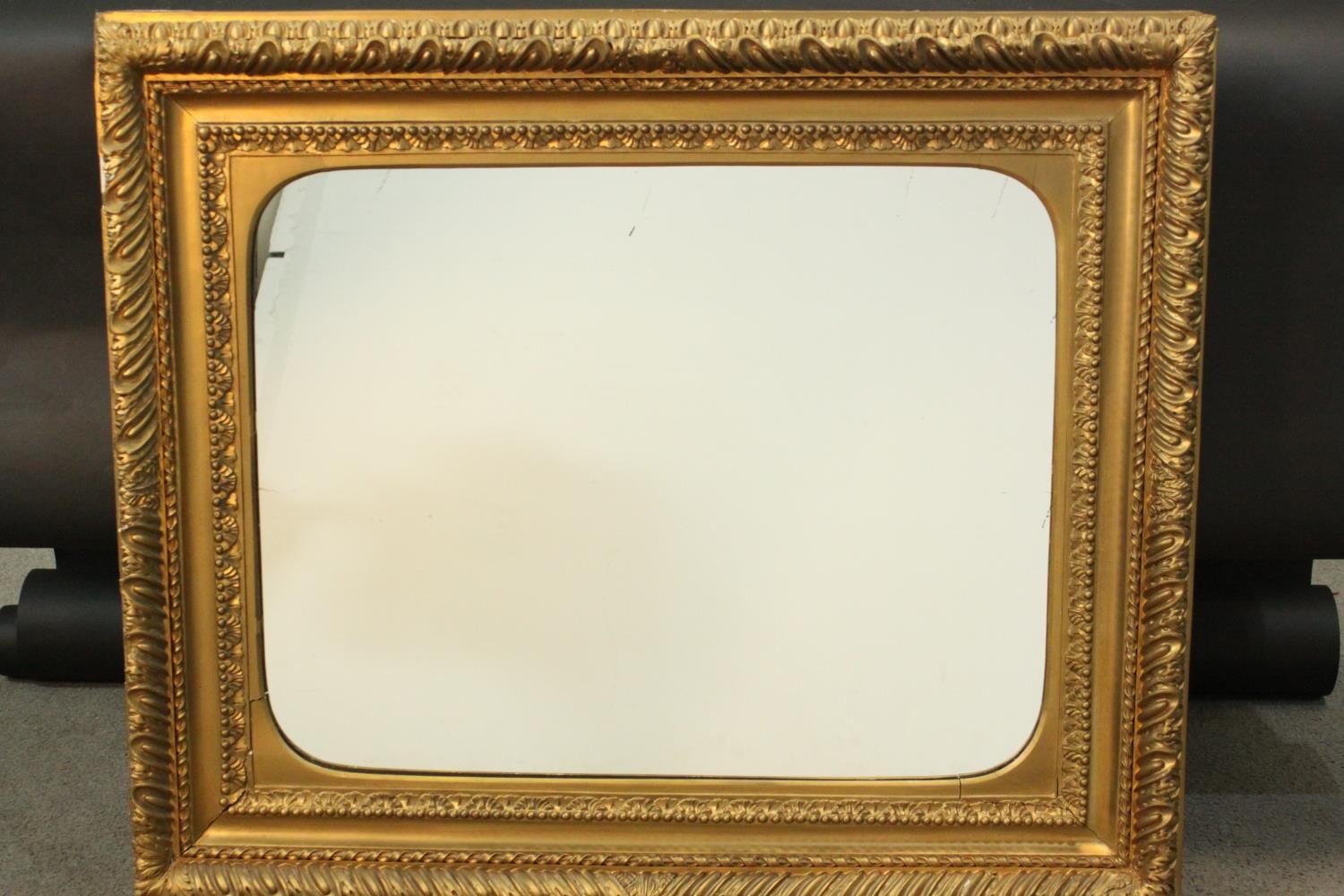 An early 20th century carved giltwood and gesso framed wall mirror. The frame decorated with