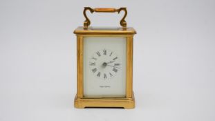 A gilt brass early 20th century carriage clock by Mappin & Webb, white enamel dial with Roman