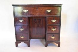 A 19th century mahogany kneehole desk with central drawer above panel cupboard flanked by pedestal