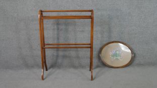 A walnut towel rail, together with an oval tea tray, the centre embroidered with a spray of flowers.