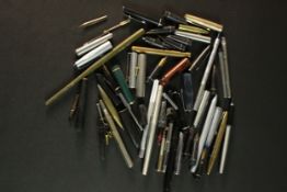 A collection of fountain pen parts including barrels, pen nibs and lids. (8)