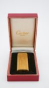 A Cartier gold plated ridged design lighter, signed Cartier, Paris, plaque d'or, in original