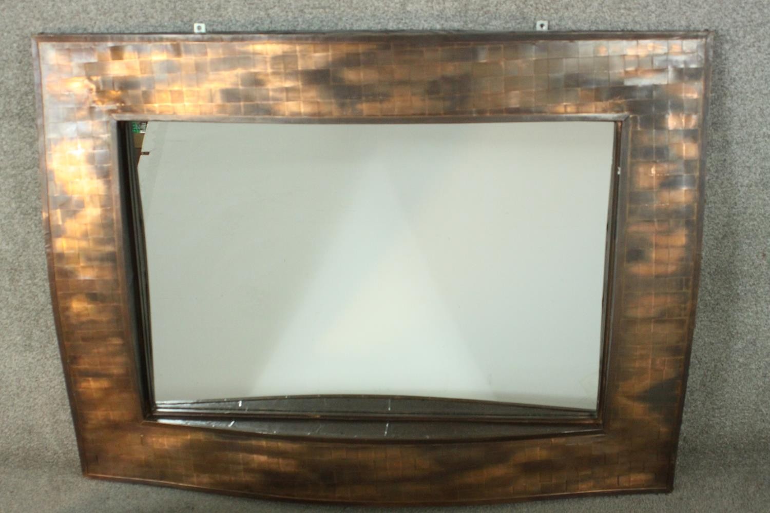 A contemporary copper framed mirror, of rectangular form, with a lattice design undulating frame.