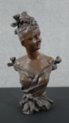 An Art Nouveau style spelter bust of a lady with her hair up and in fine dress. Indistinctly