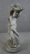 A large reconstituted stone bird bath in the form of a nude female holding a sea shell. Indistinctly